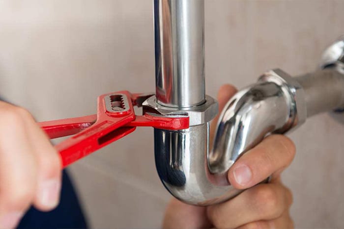 plumbing pipes being tightened to avoid leaks